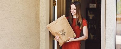Woman picking up a package off the front porch
